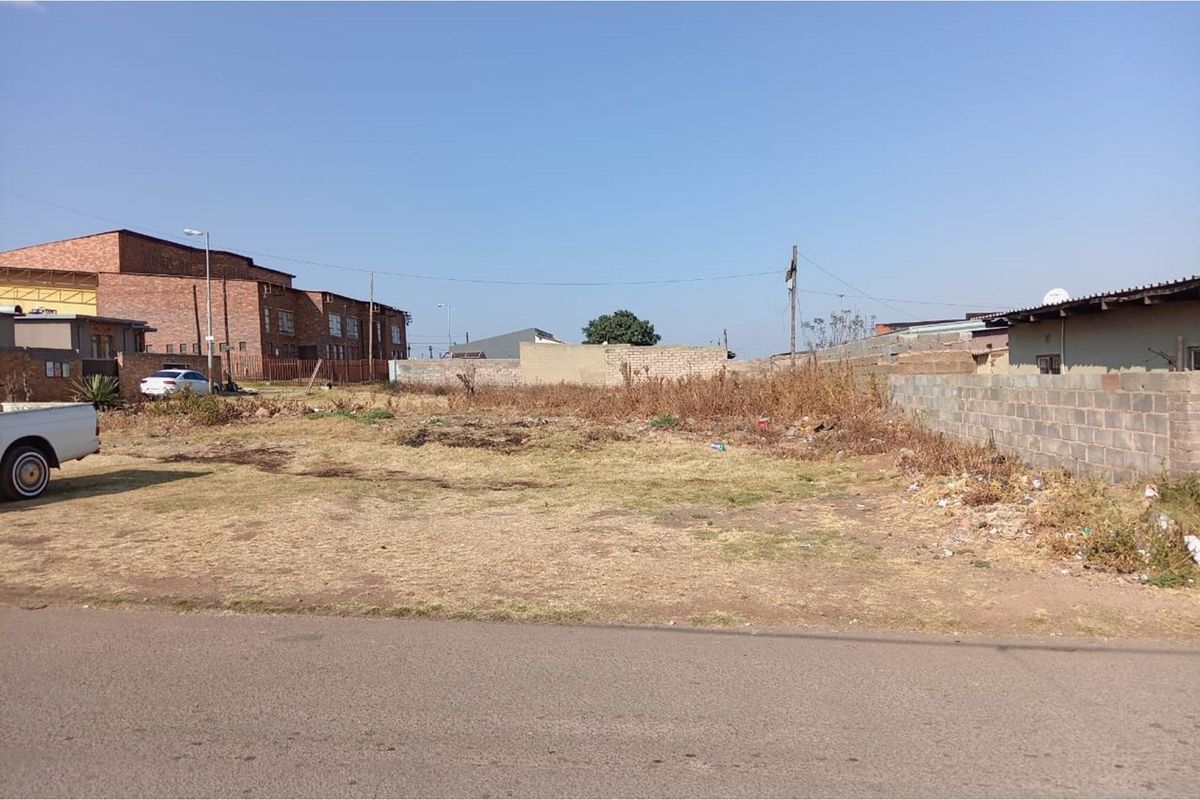 A vacant residential plot featuring boundary walls and direct street access, ready for development.