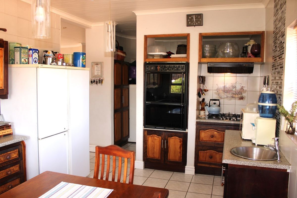 A functional kitchen featuring built-in cabinetry, a wall-mounted oven, gas hob, and tiled flooring with a compact prep area.