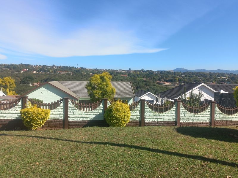A scenic elevated view overlooking the surrounding residential neighbourhood and distant hills, framed by a decorative precast concrete boundary wall.