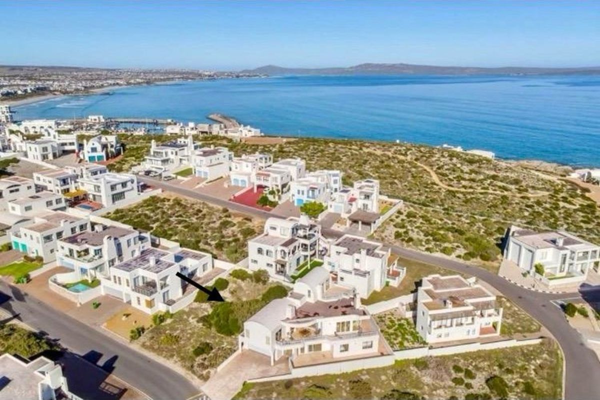 Aerial view of a coastal residential estate featuring multi-level homes situated near the ocean.