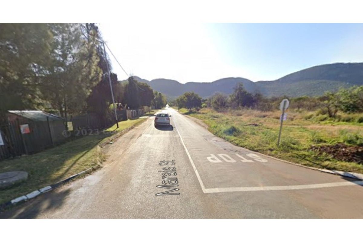 A street view showing the approach to the property location with surrounding landscape and mountain views.