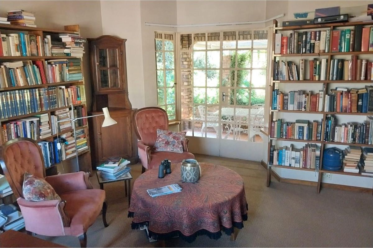 A cozy living room featuring built-in shelving units and large glass paneled doors leading out to a covered patio area.