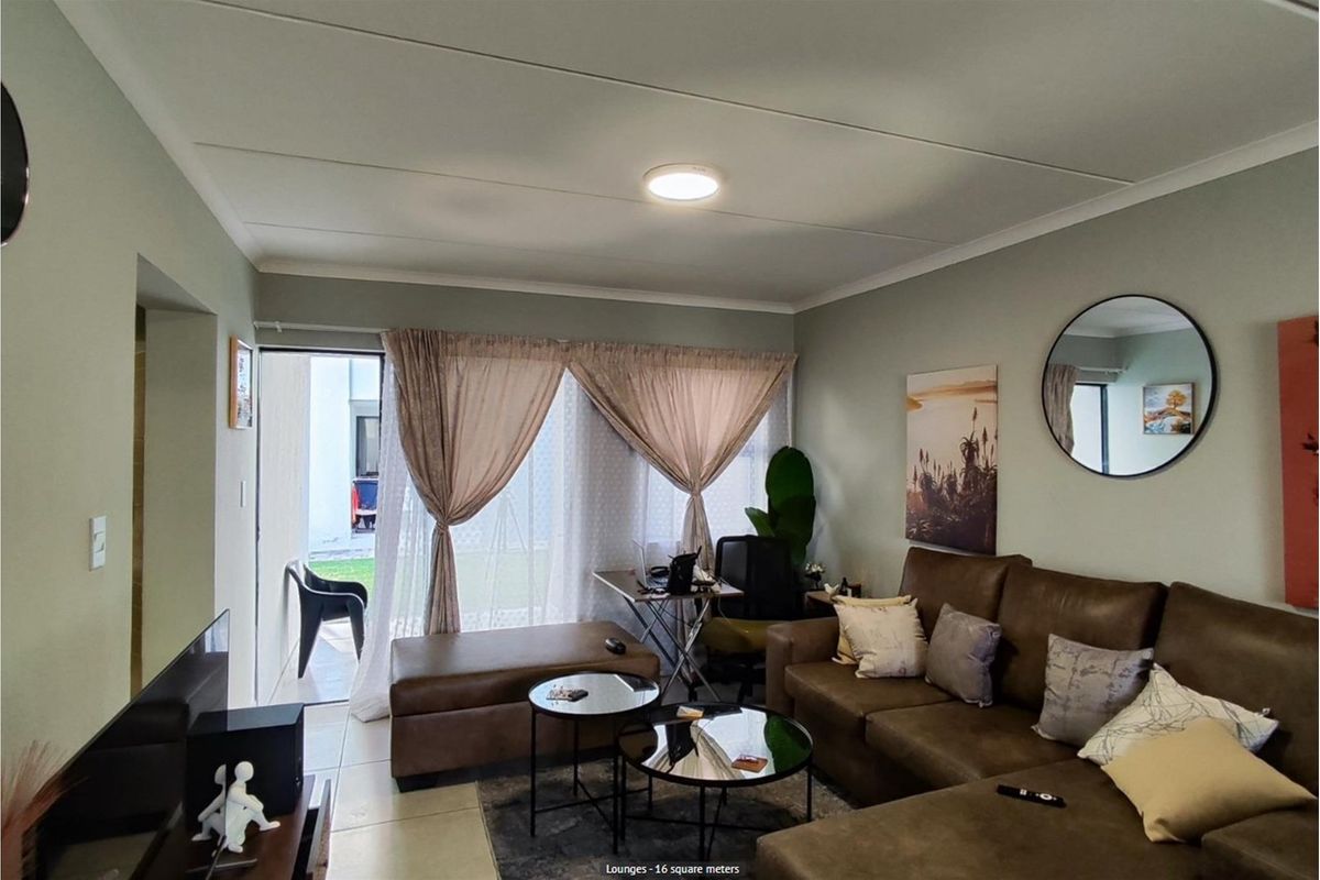 A comfortable living room featuring tiled flooring, a ceiling-mounted light fixture, and sliding glass doors that provide direct access to an outdoor patio area.