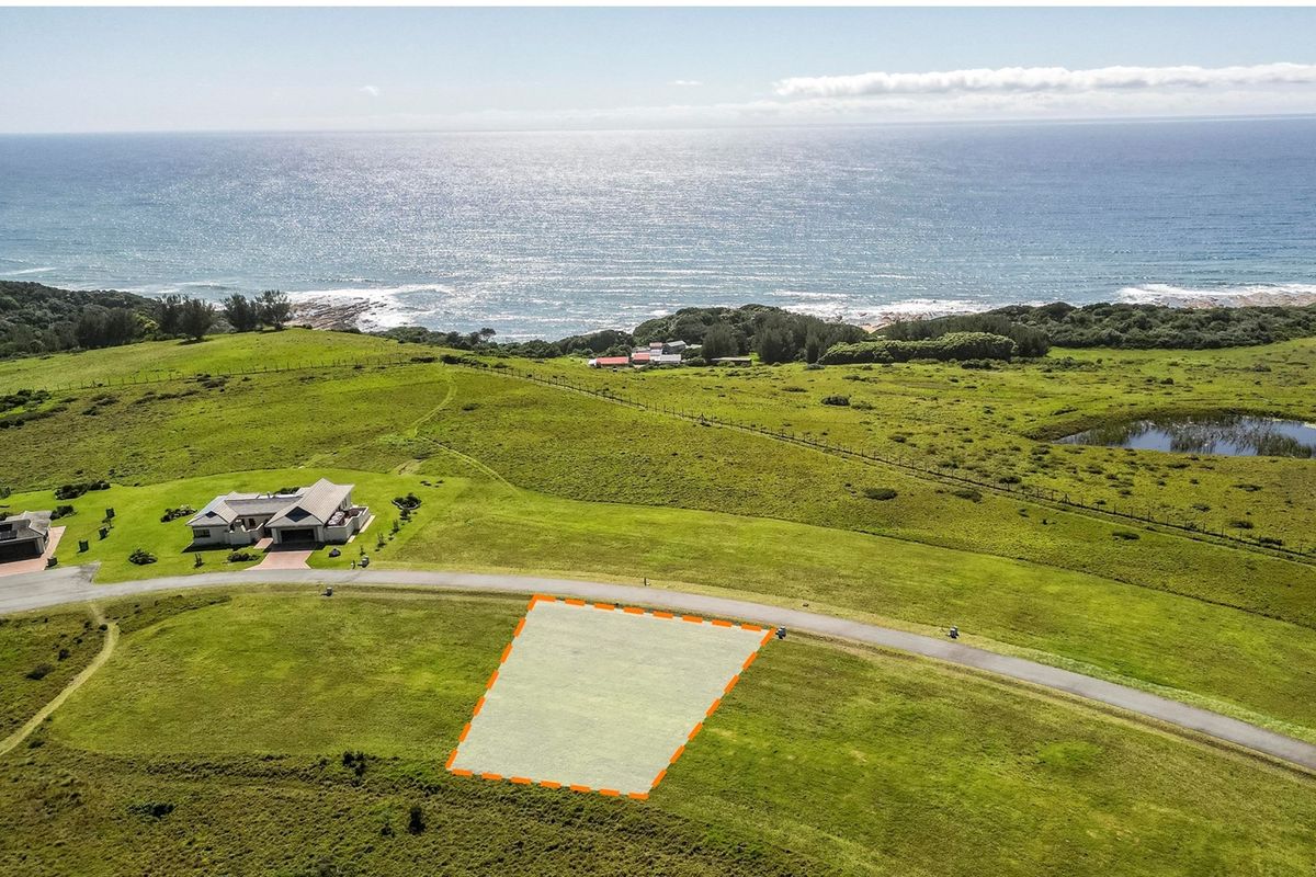 An aerial view of a vacant residential plot featuring expansive coastal and ocean views in a scenic estate setting.