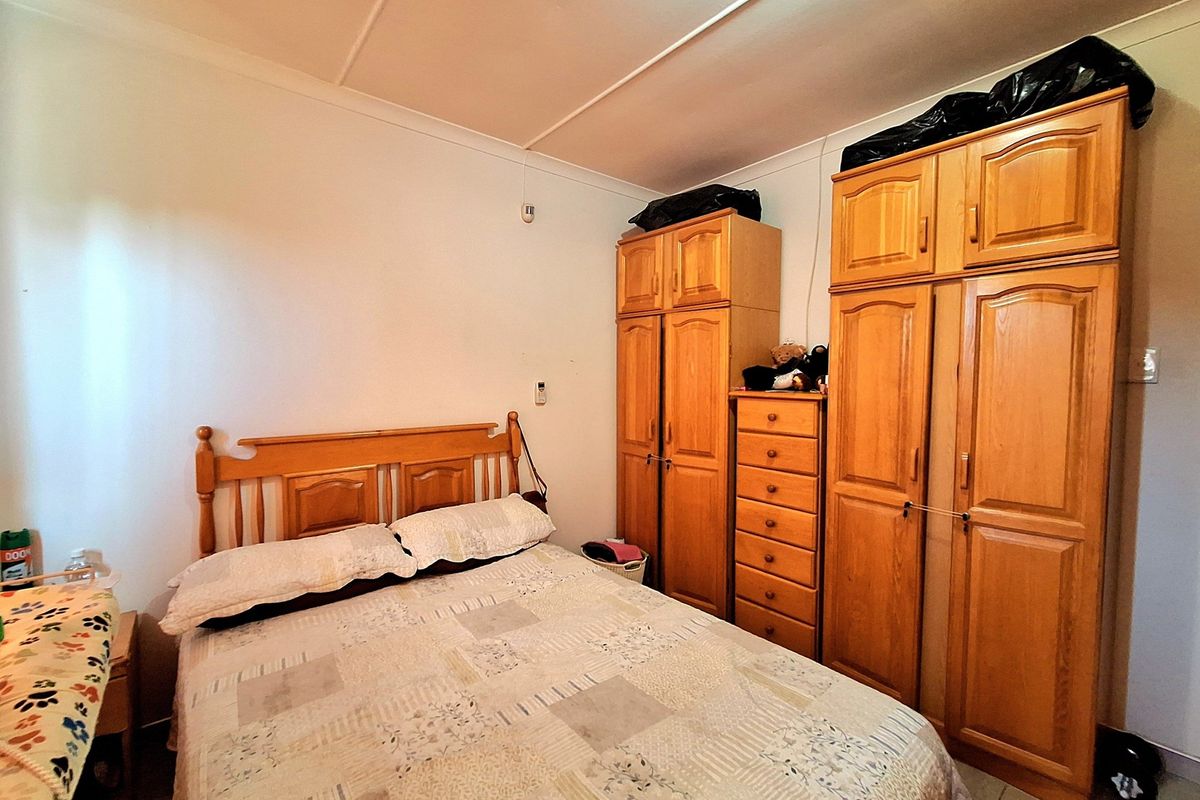 A bedroom featuring built-in wooden cabinetry and tiled flooring, offering functional storage space.