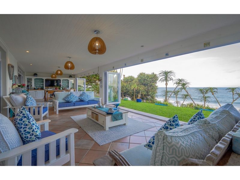 Spacious covered patio featuring tiled flooring, recessed lighting, and seamless indoor-outdoor flow with expansive ocean views.