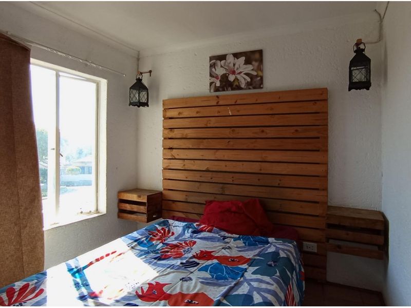 A bedroom featuring a sliding window, textured wall finishes, and integrated electrical outlets.