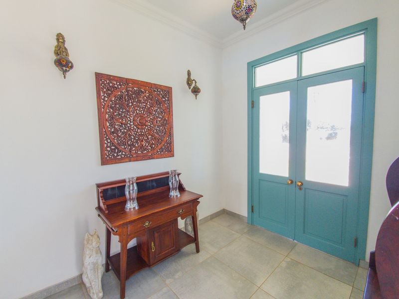 Welcoming entrance foyer featuring a distinctive teal double door with glass inserts and neutral tiled flooring.