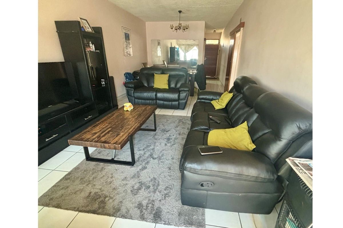 A spacious living room featuring tiled flooring and a neutral color palette, providing a comfortable and functional area for relaxation.