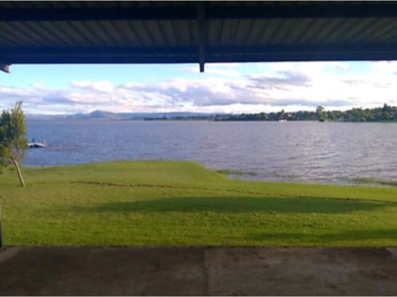 A covered patio area offering expansive, unobstructed views of the lake and surrounding landscape.