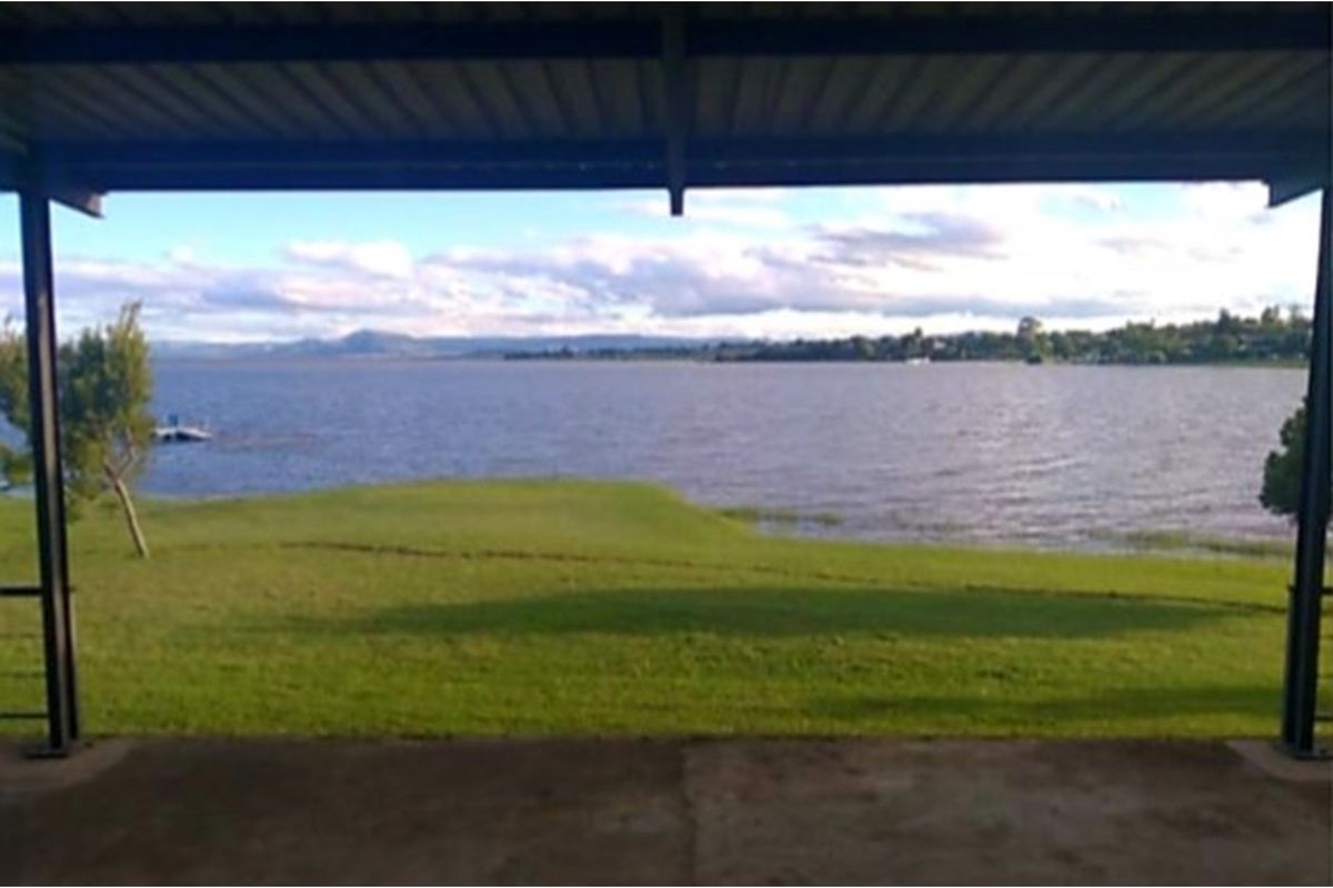 A covered patio area offering expansive, unobstructed views of the lake and surrounding landscape.