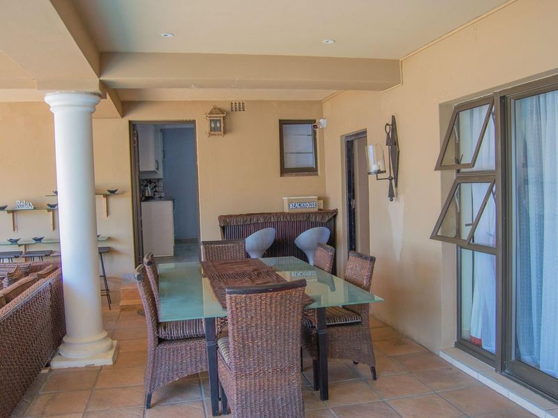 Covered patio area featuring tiled flooring, recessed lighting, and access to the interior, providing a functional outdoor entertainment space.