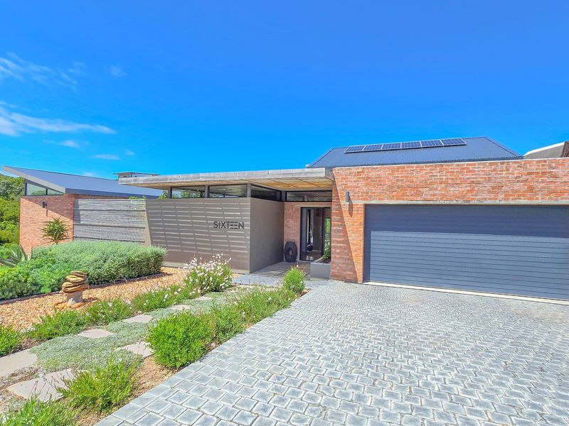 Modern single-story residence featuring a brick facade, double garage, paved driveway, and solar panels, set within a well-maintained landscaped garden.