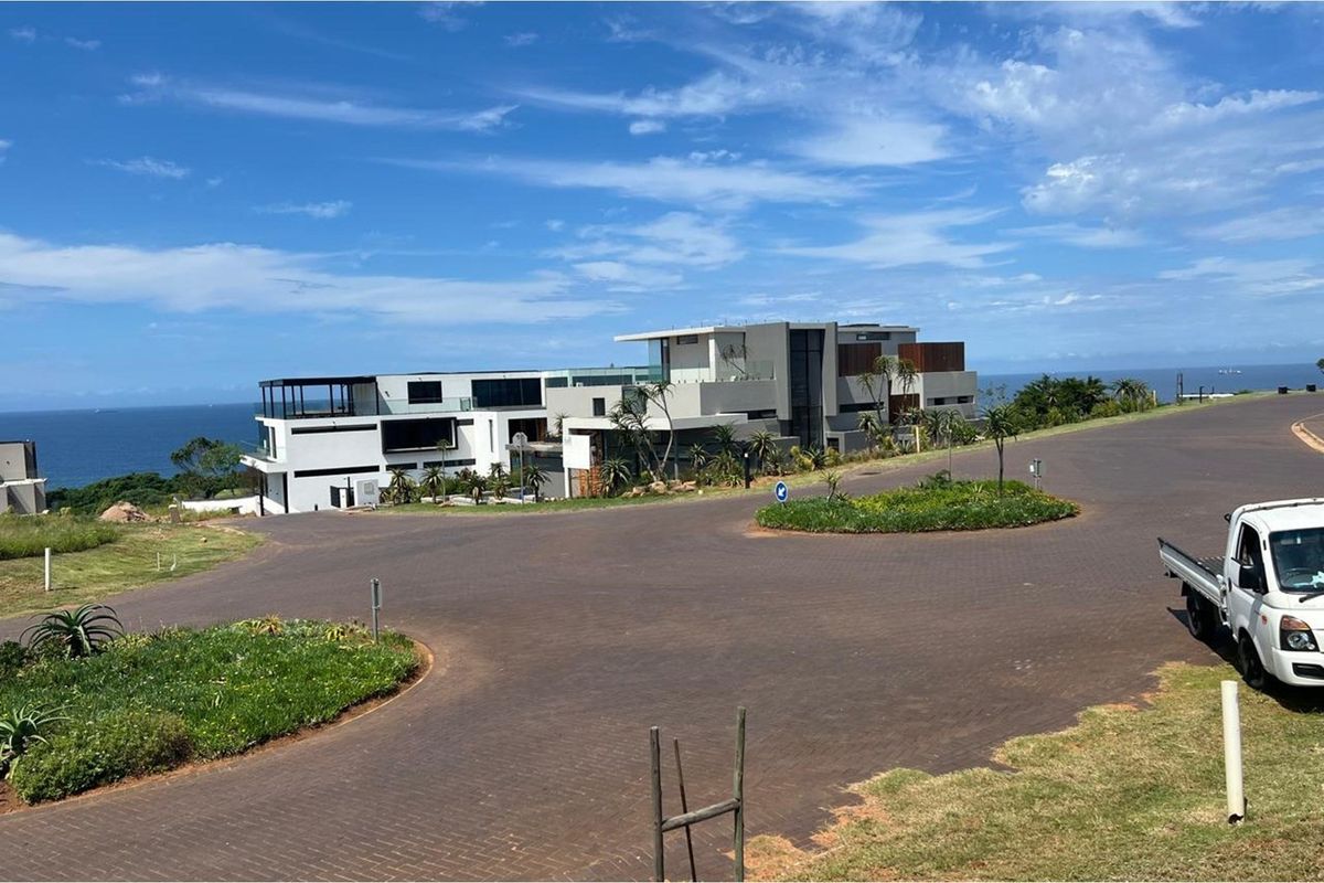 A view of a modern residential property from the street, showcasing its architectural design and coastal location.