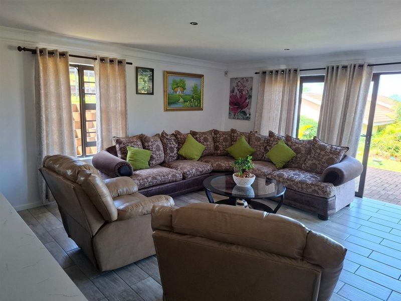 Spacious living room featuring tiled flooring, recessed ceiling lighting, and large sliding glass doors providing access to the outdoor area.
