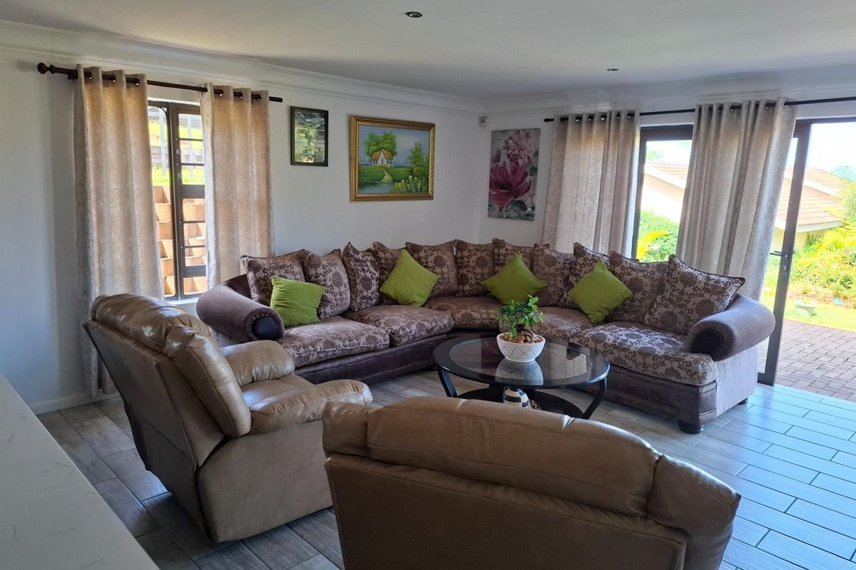 Spacious living room featuring tiled flooring, recessed ceiling lighting, and large sliding glass doors providing access to the outdoor area.