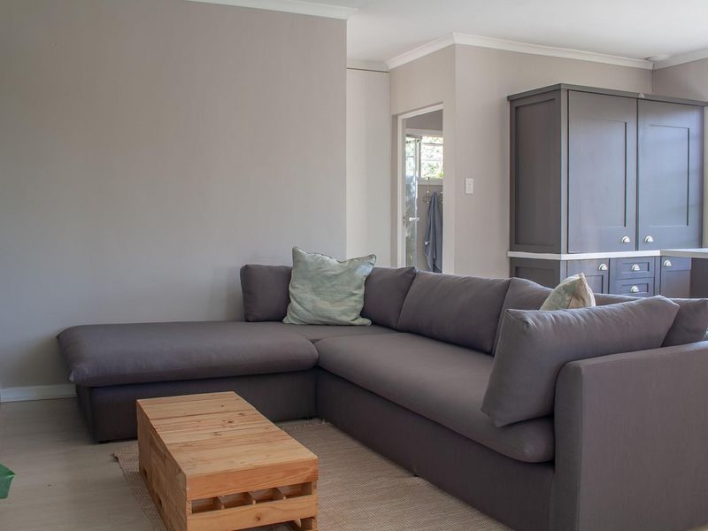 A well-maintained living room featuring neutral wall tones, laminate flooring, and built-in cabinetry, offering a clean and functional living space.