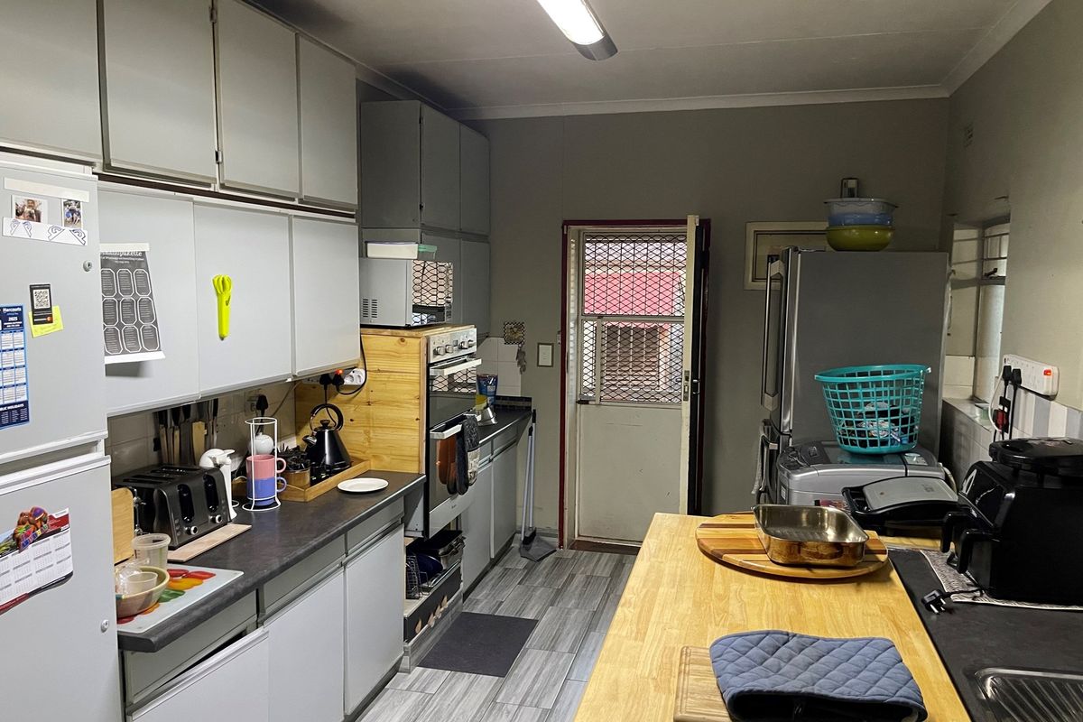 Functional kitchen featuring built-in cabinetry, integrated oven, and direct access to the exterior via a security door.