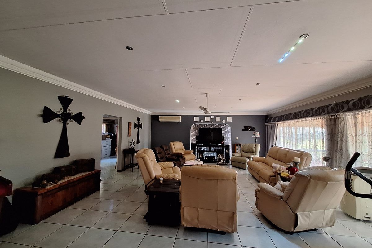 Spacious living room featuring tiled flooring, recessed downlighting, and a wall-mounted air conditioning unit.