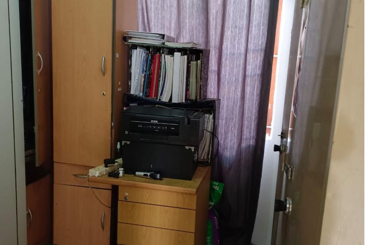 A bedroom featuring a built-in wooden wardrobe and integrated desk unit, providing functional storage and workspace within the room.