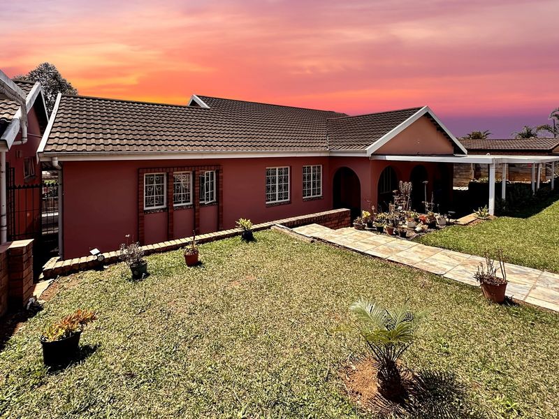 A well-maintained single-story residential property featuring a tiled roof, brick facade, and a paved walkway leading to a covered patio area.