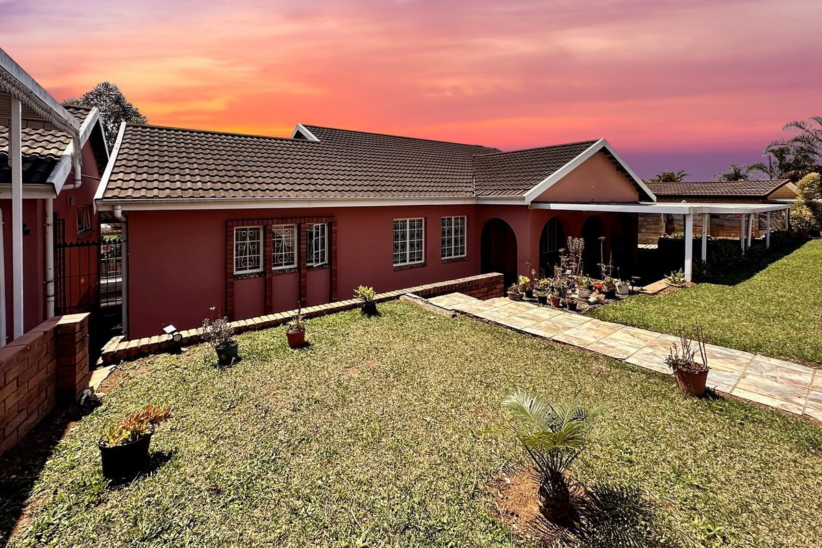 A well-maintained single-story residential property featuring a tiled roof, brick facade, and a paved walkway leading to a covered patio area.