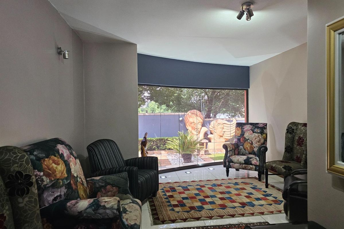 A living room featuring large glass sliding doors that provide a seamless connection to the outdoor garden area.