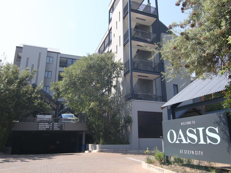 Exterior view of the Oasis at Steyn City apartment complex, featuring modern architectural design, balconies, and secure basement parking access.