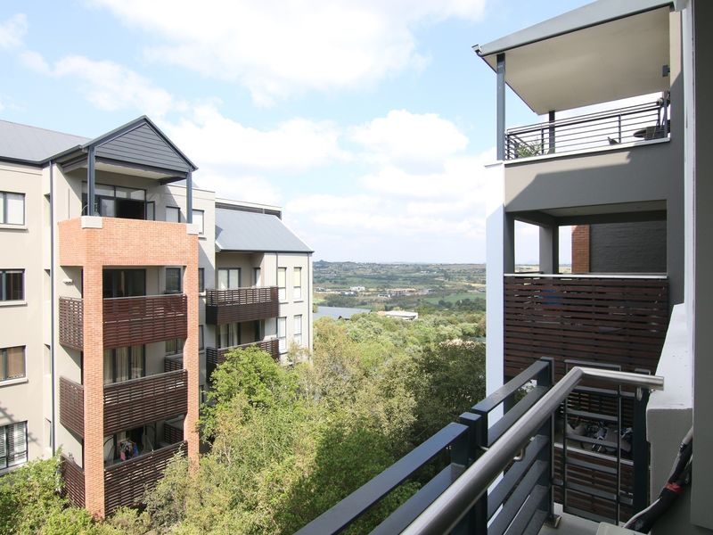 A view from a balcony overlooking the surrounding apartment complex and natural landscape.