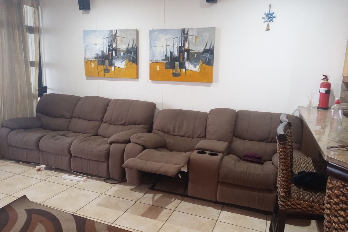 A living area featuring tiled flooring and a breakfast bar counter, providing a functional space for relaxation and casual dining.