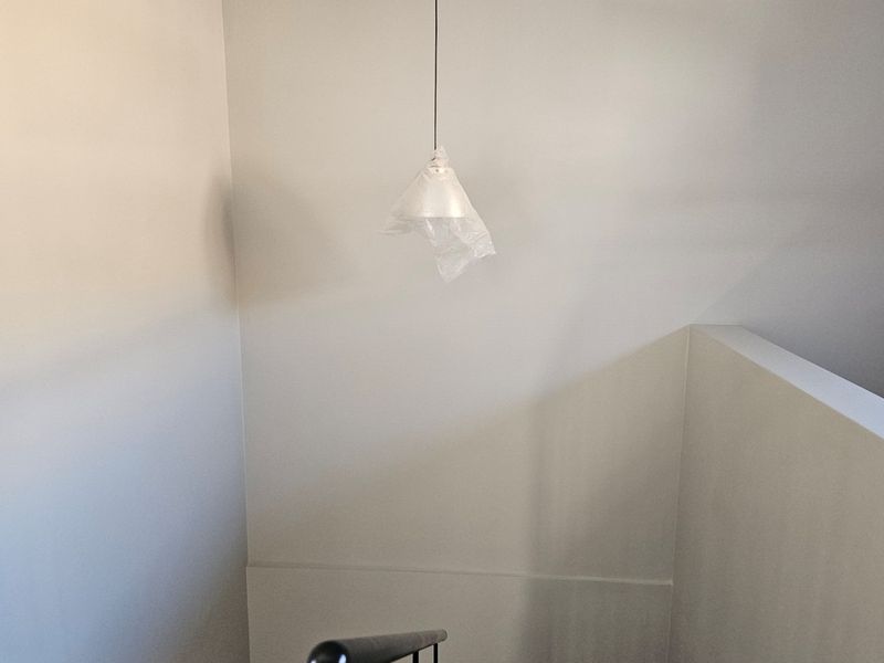 A simple staircase landing area featuring neutral walls and a single pendant light fixture.