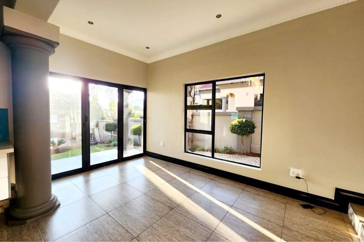 Bright and spacious living area featuring large glass sliding doors, modern tiled flooring, and a decorative structural column.