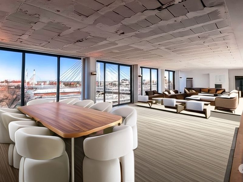 Spacious open-plan living and dining area featuring floor-to-ceiling windows with expansive city and bridge views and an industrial-style exposed concrete ceiling.