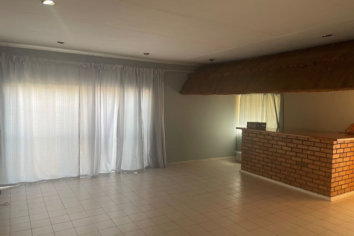 Spacious living area featuring a built-in brick bar with a thatched roof detail and large sliding glass doors leading to the exterior.