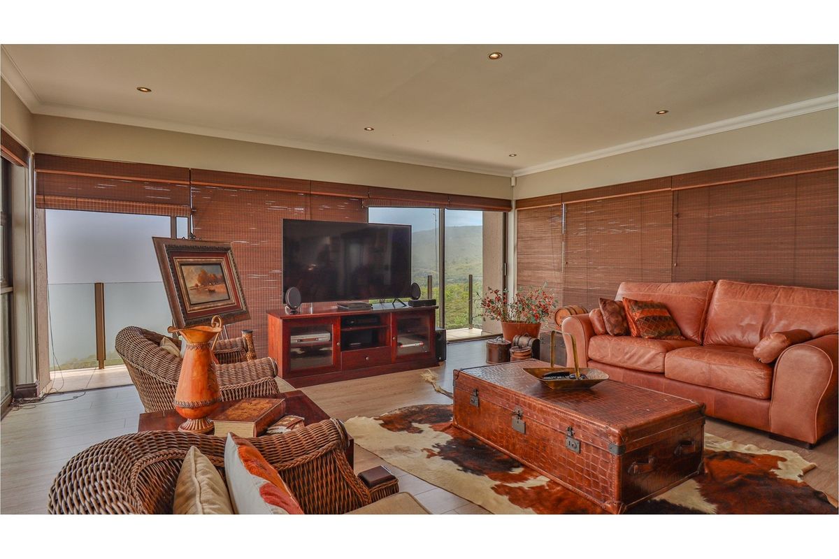 Spacious living room featuring large sliding glass doors, recessed ceiling lighting, and neutral flooring, offering seamless access to an outdoor balcony area.