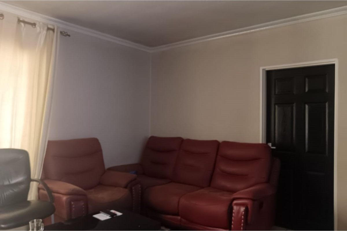 A living room area featuring crown molding and a dark-finished interior door.