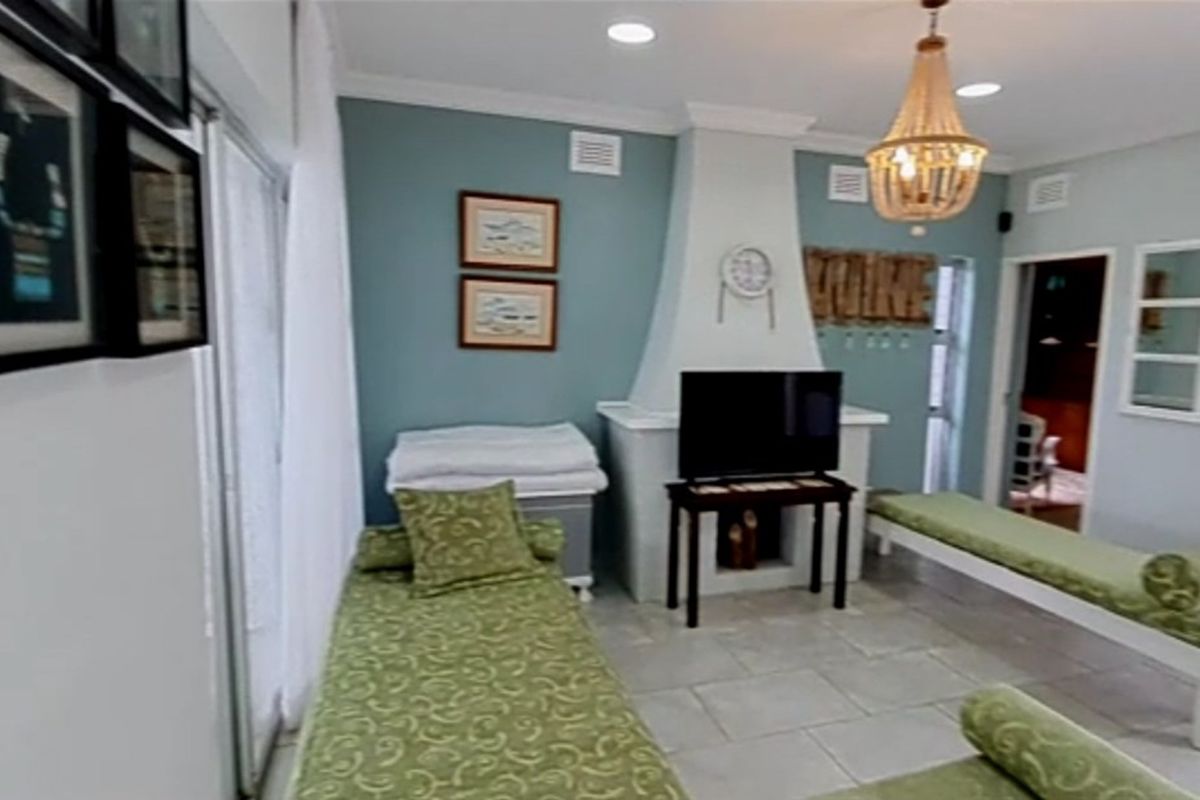 A living room featuring a central fireplace, tiled flooring, and sliding glass doors providing access to the exterior.