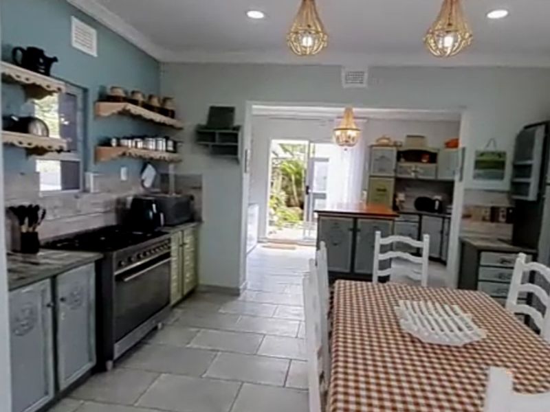 Open-plan kitchen and dining area featuring tiled flooring, built-in cabinetry, and direct access to the outdoor space through a sliding glass door.