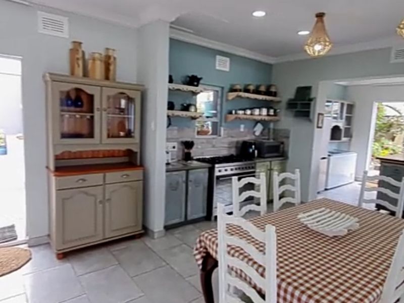 Open-plan kitchen and dining area featuring tiled floors, built-in cabinetry, and a gas stove, with direct access to an outdoor space.