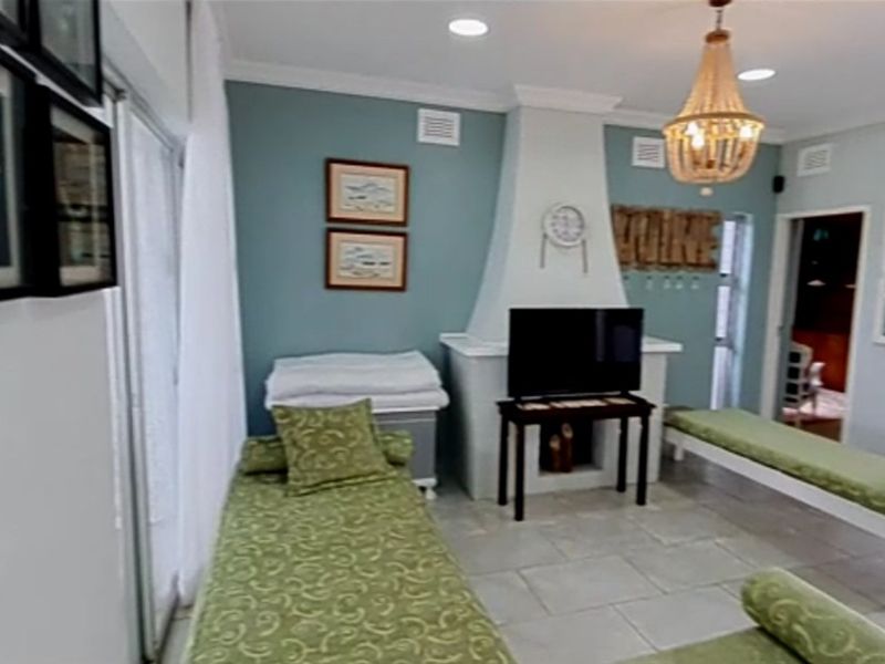 A living room featuring a central fireplace, tiled flooring, and sliding glass doors providing access to the exterior.