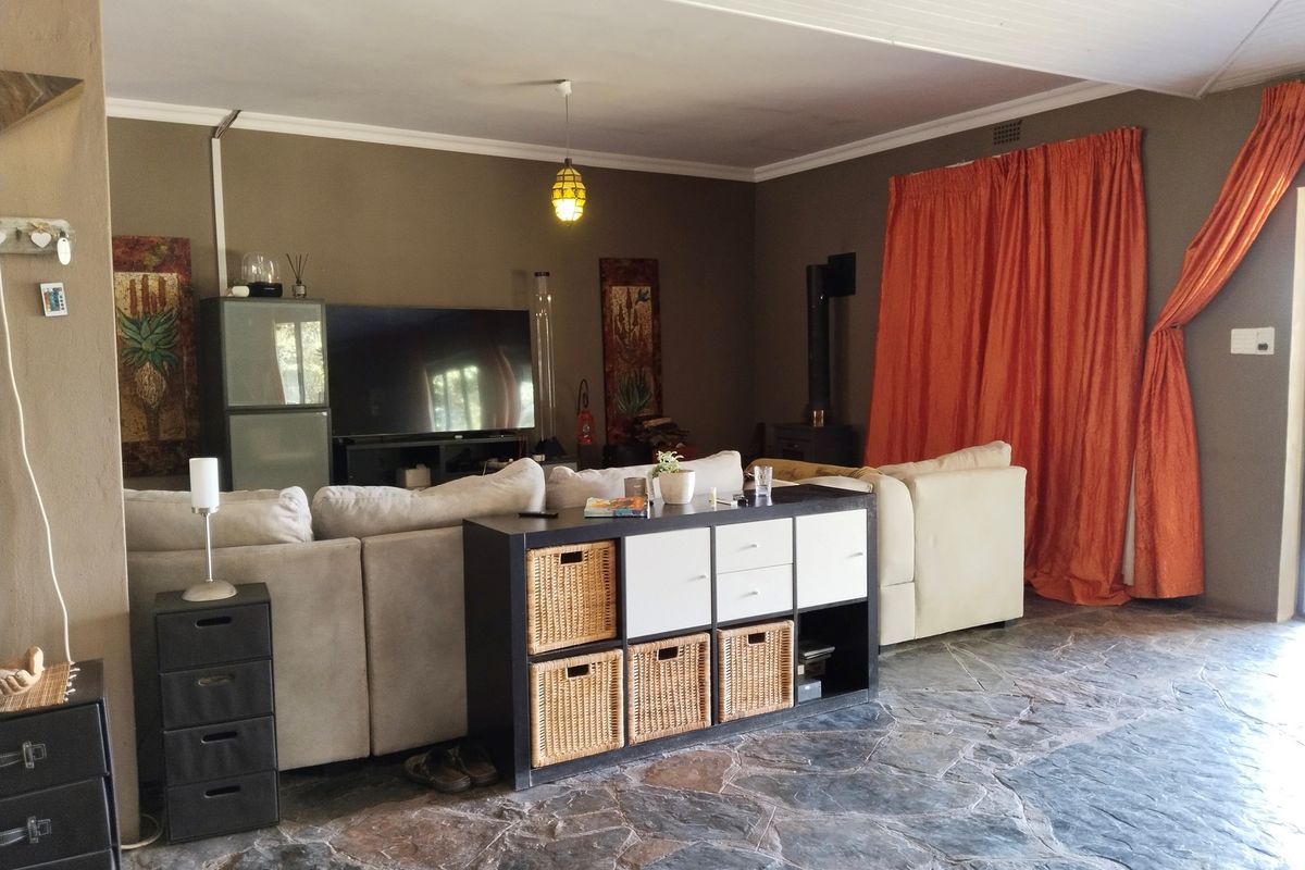 Spacious living area featuring natural stone flooring, a built-in fireplace, and neutral wall tones, creating a comfortable and functional family space.