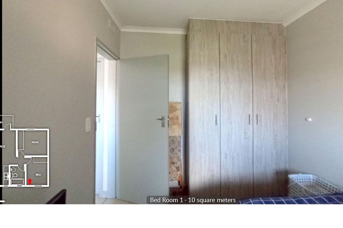 A bedroom featuring built-in wooden cabinetry and neutral wall finishes, providing a functional and clean living space.