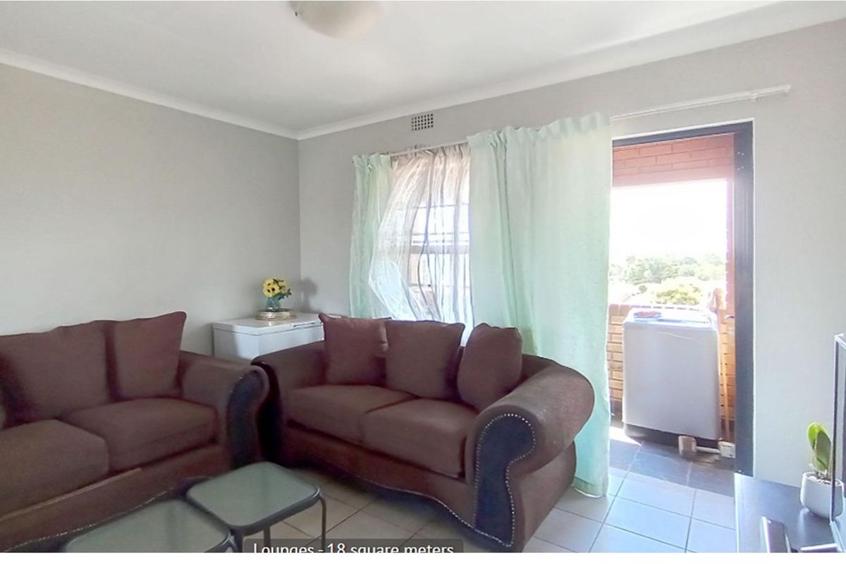 A living room area featuring tiled flooring and direct access to an outdoor balcony space.