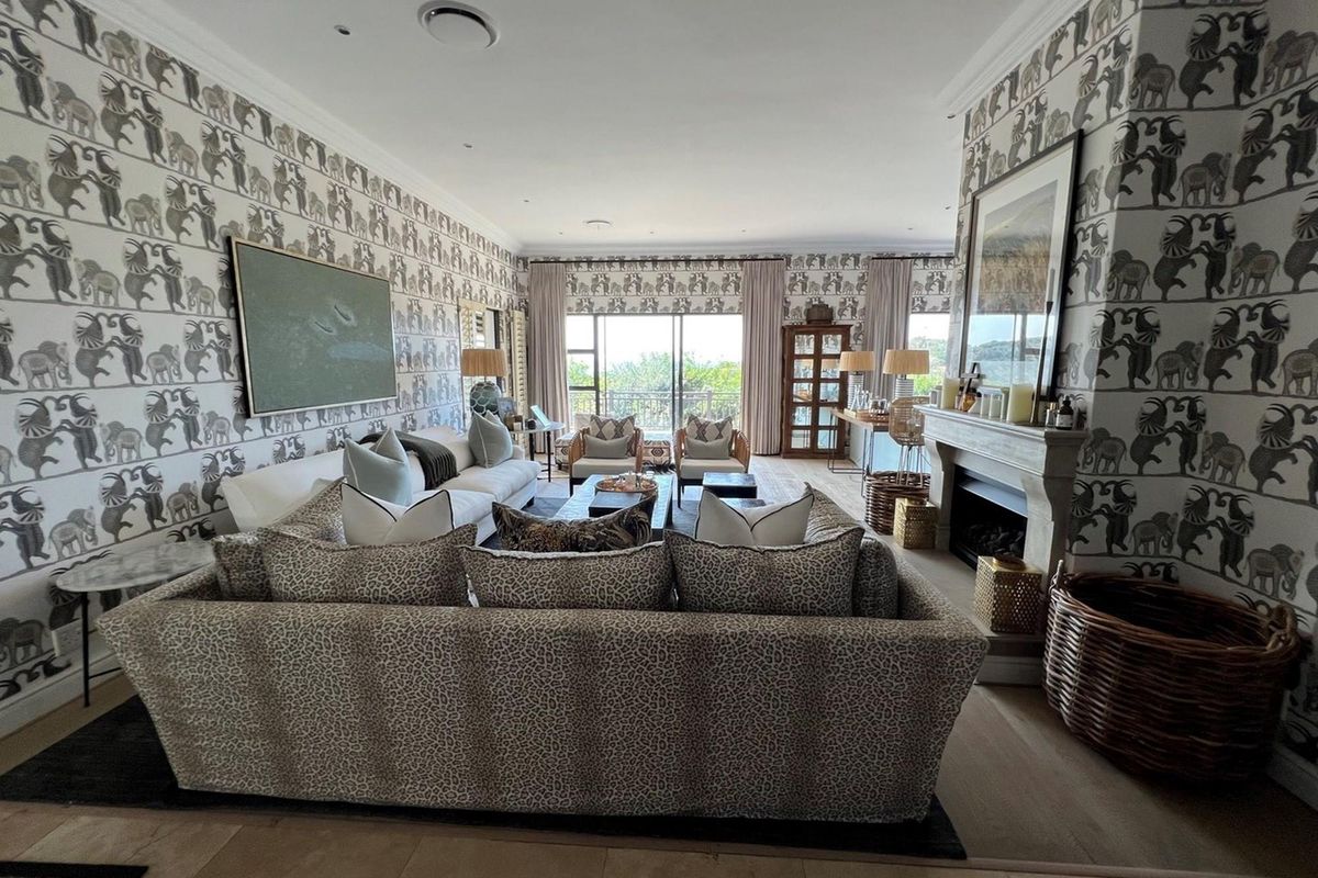 Spacious living room featuring a stone fireplace, crown molding, and large sliding glass doors that provide natural light and access to the outdoor area.
