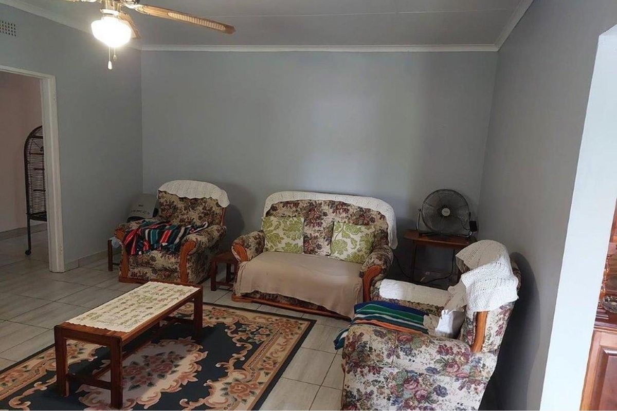 A living room featuring tiled flooring and a ceiling fan, providing a functional and neutral space for relaxation.