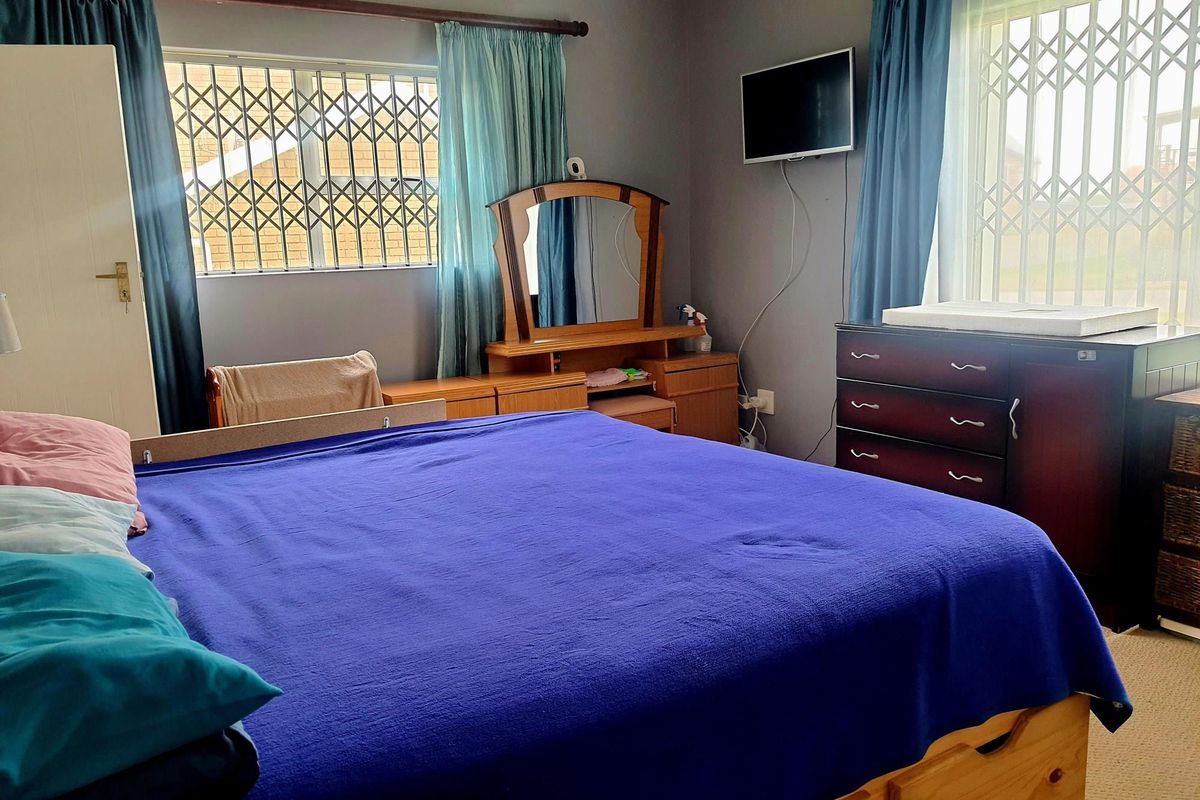 A bedroom featuring security gates on the windows and neutral wall finishes.