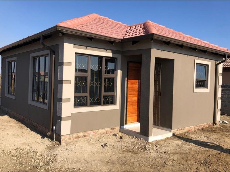 A modern single-story detached house featuring a tiled roof, painted exterior walls with decorative quoins, and secure metal-framed windows.