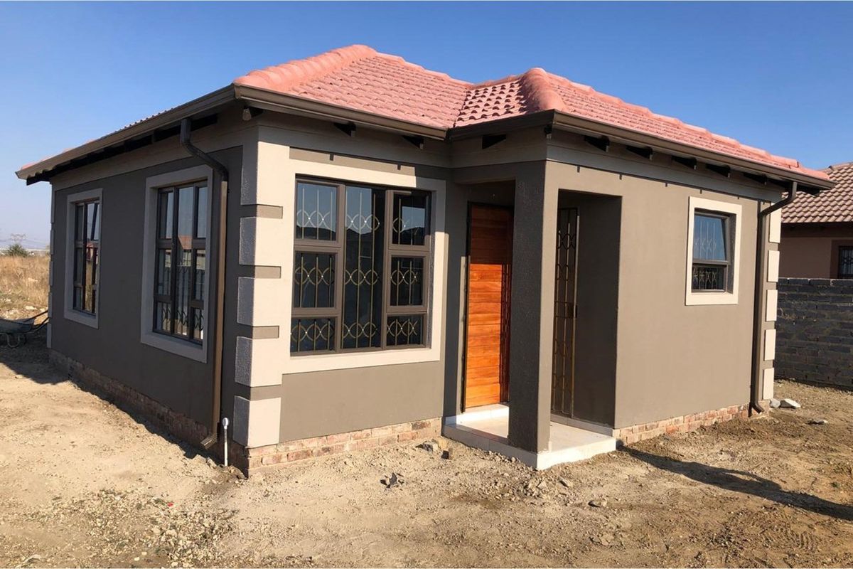 A modern single-story detached house featuring a tiled roof, painted exterior walls with decorative quoins, and secure metal-framed windows.