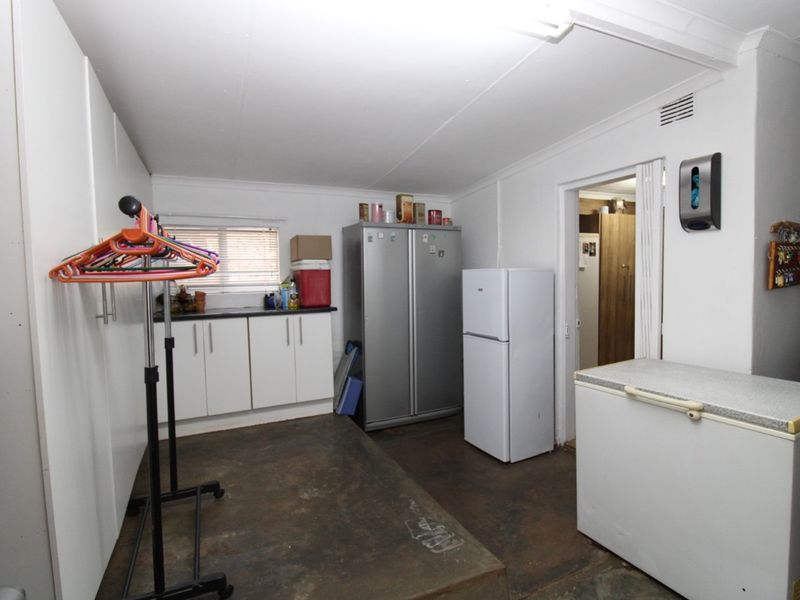 Functional laundry or utility space featuring built-in cabinetry, ample storage capacity, and direct access to adjacent rooms.