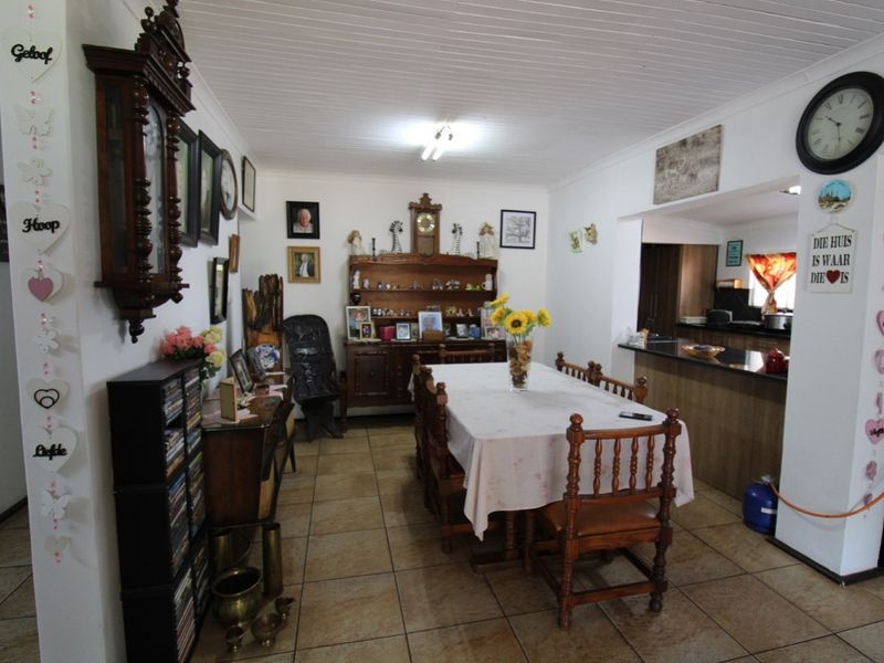 Open plan dining area featuring tiled flooring and a breakfast bar counter leading into the kitchen space.